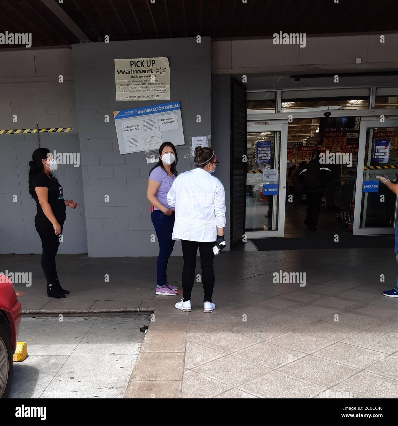 Menschen mit Gesichtsmasken warten in der Schlange, um einen Supermarkt in guatemala-Stadt zu betreten Stockfoto