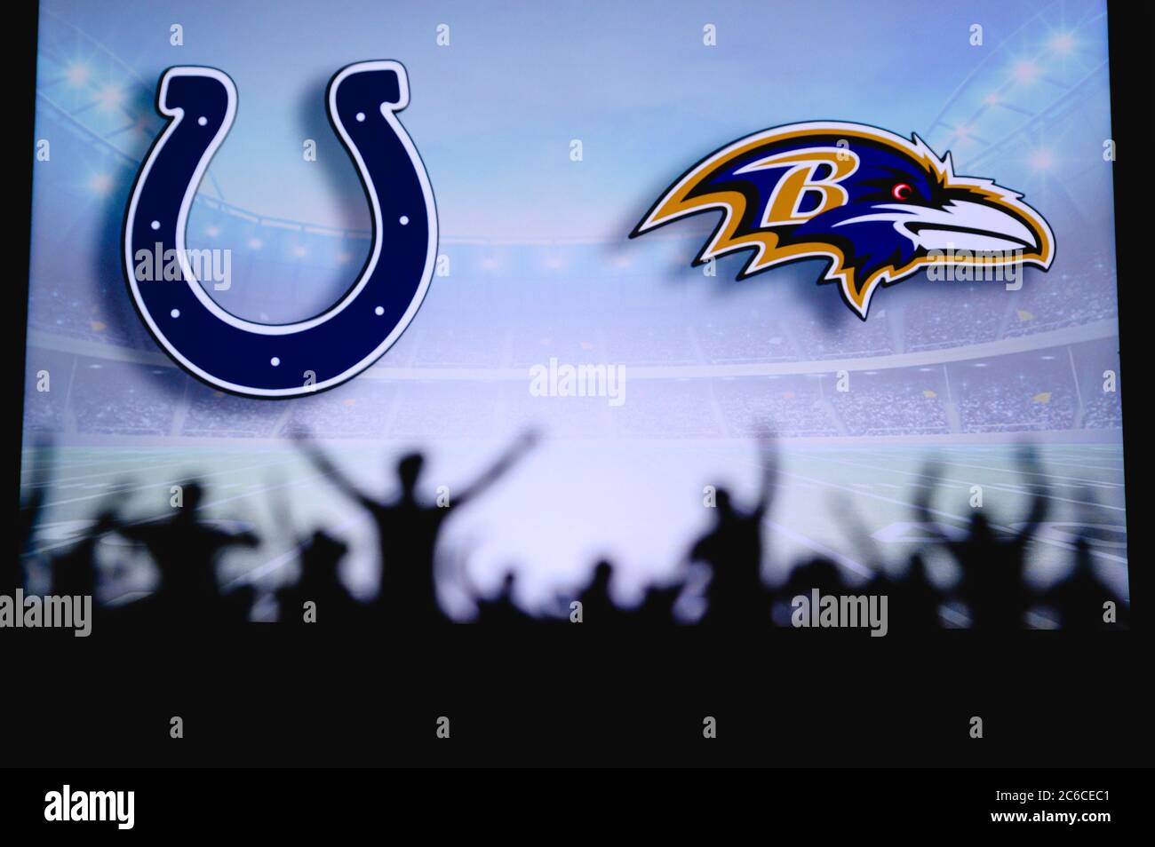 Indianapolis Colts gegen Baltimore Ravens. Fans unterstützen NFL Game. Silhouette der Unterstützer, große Leinwand mit zwei Rivalen im Hintergrund. Stockfoto