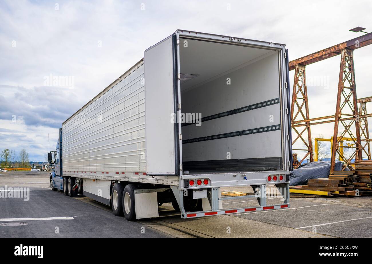 Professionelle Qualität Big Rig blau semi-Truck mit offener Tür leer Auflieger auf Lager Parkplatz am Industriegebiet warten auf die comm Stockfoto