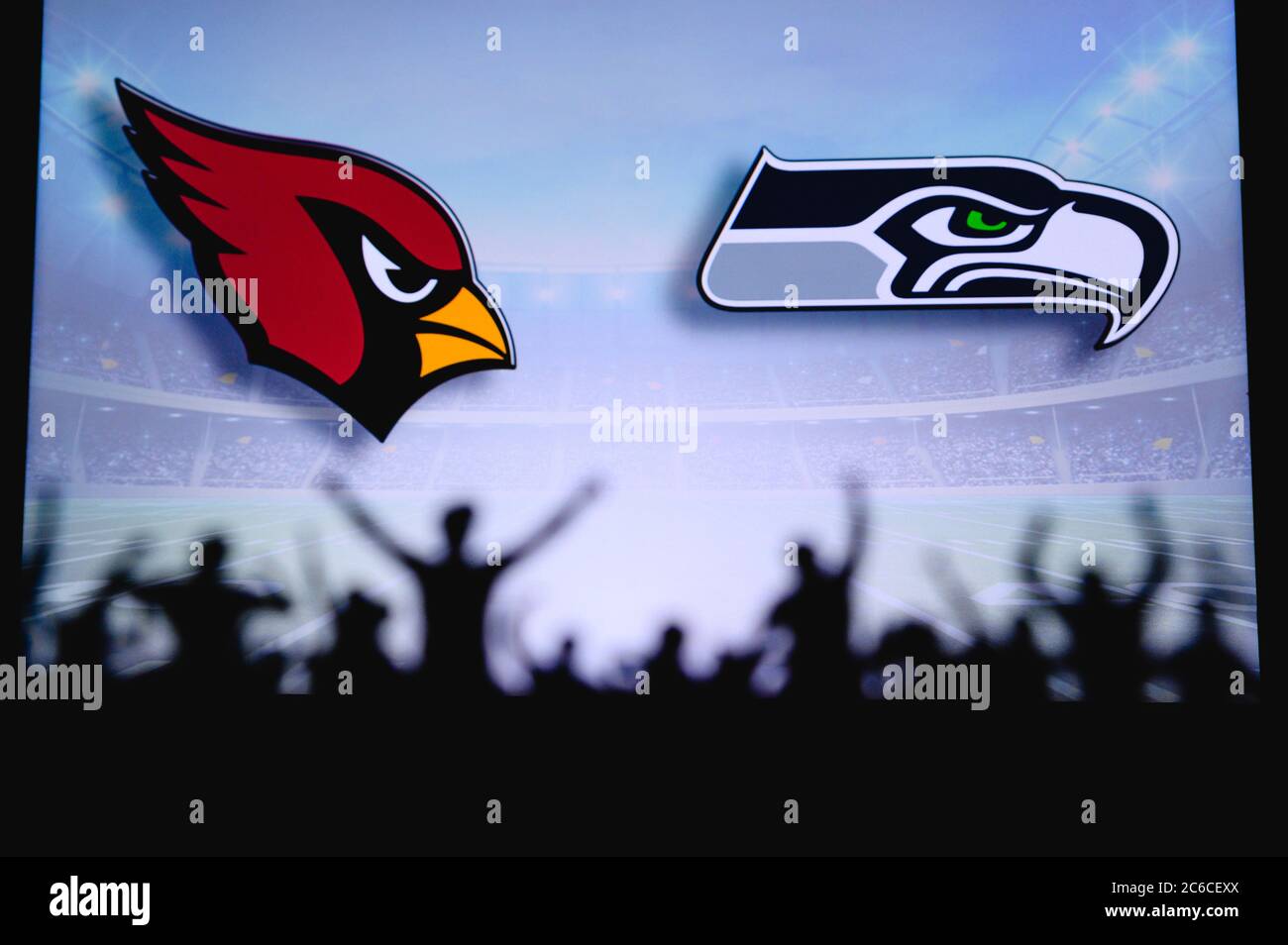 Arizona Cardinals gegen Seattle Seahawks. Fans unterstützen NFL Game. Silhouette der Unterstützer, große Leinwand mit zwei Rivalen im Hintergrund. Stockfoto