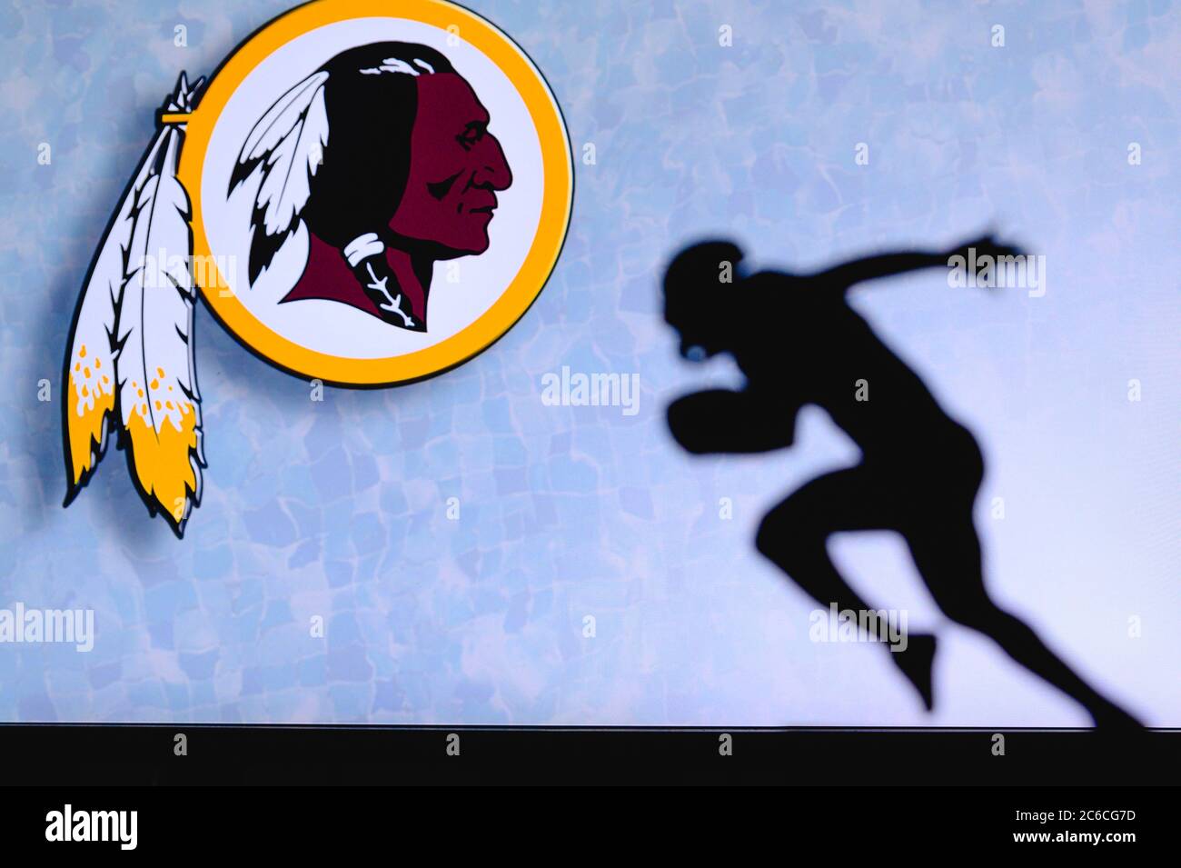 Washington Redskins. Silhouette des professionellen amerikanischen Fußballspielers. Logo des NFL-Clubs im Hintergrund, bearbeiten Raum. Stockfoto