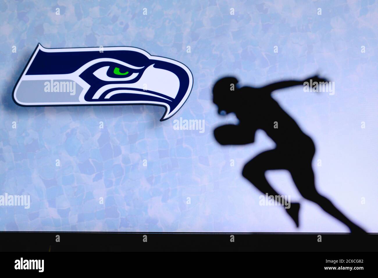 Seattle Seahawks. Silhouette des professionellen amerikanischen Fußballspielers. Logo des NFL-Clubs im Hintergrund, bearbeiten Raum. Stockfoto