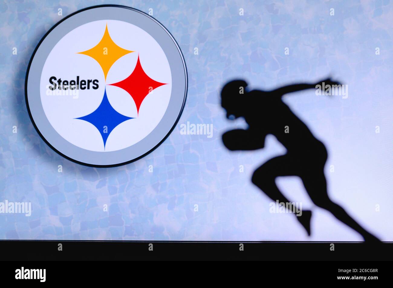 Pittsburgh Steelers Silhouette des professionellen amerikanischen Fußballspielers. Logo des NFL-Clubs im Hintergrund, bearbeiten Raum. Stockfoto