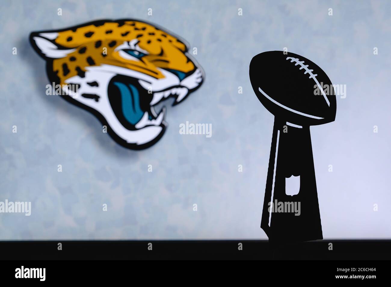 Jacksonville Jaguars professioneller amerikanischer Fußballverein, Silhouette der NFL-Trophäe, Logo des Vereins im Hintergrund. Stockfoto