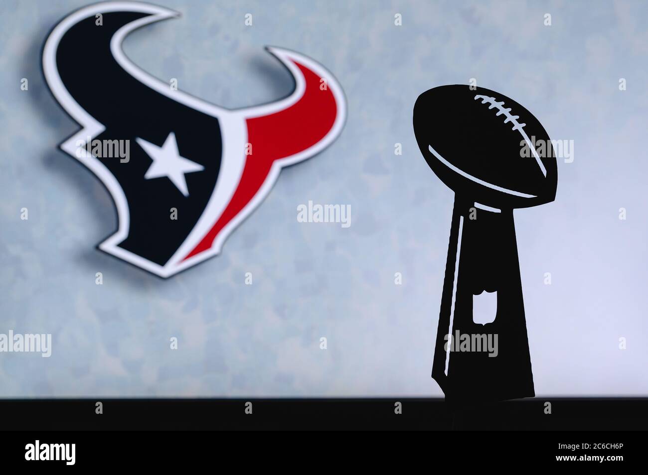 Houston Texans professionelle american Football Club, Silhouette der NFL-Trophäe, Logo des Vereins im Hintergrund. Stockfoto