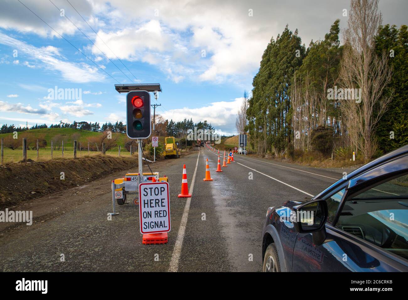 Straßenarbeiten sind im Gange, so dass die Fahrzeuge an der roten Ampel angehalten werden, da es sich vorübergehend um eine einspurige Straße handelt, Neuseeland Stockfoto