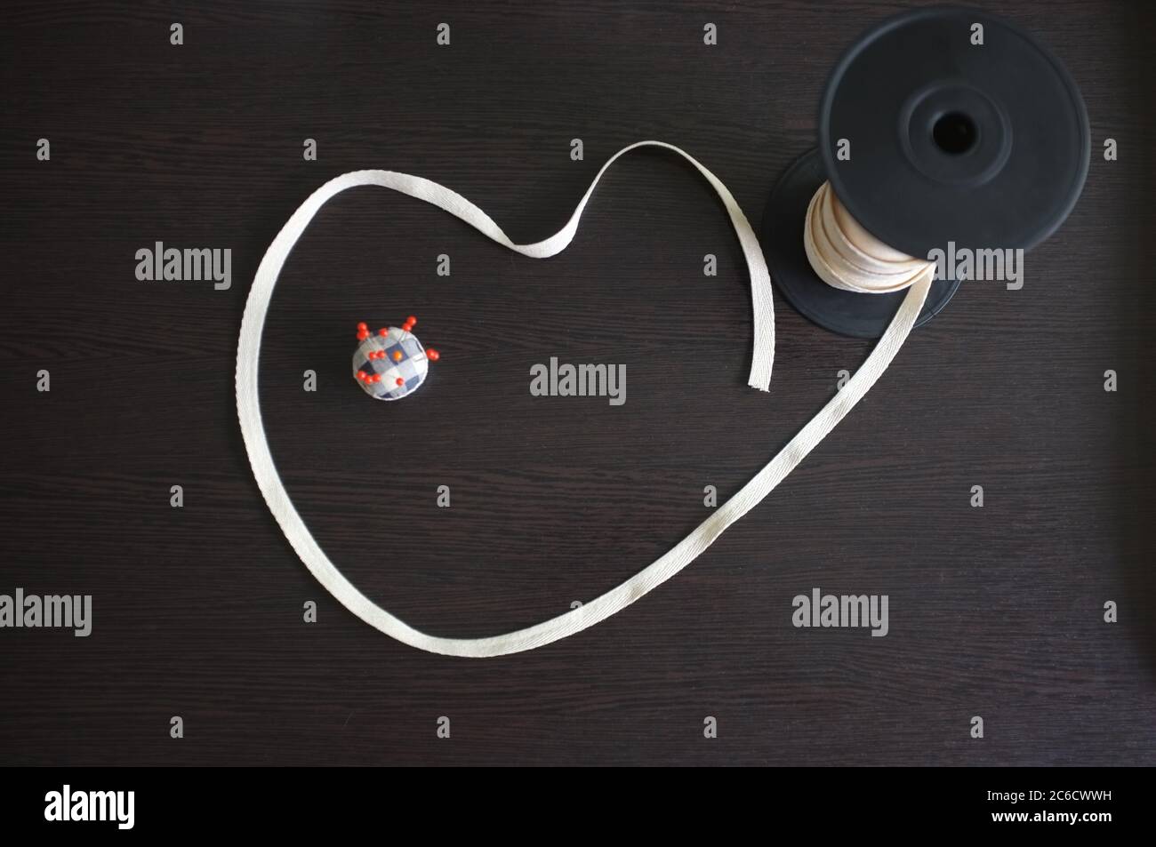 Set von Schneiderwerkzeugen und Zubehör auf einem schwarzen Holzhintergrund. Leerzeichen für Text Stockfoto