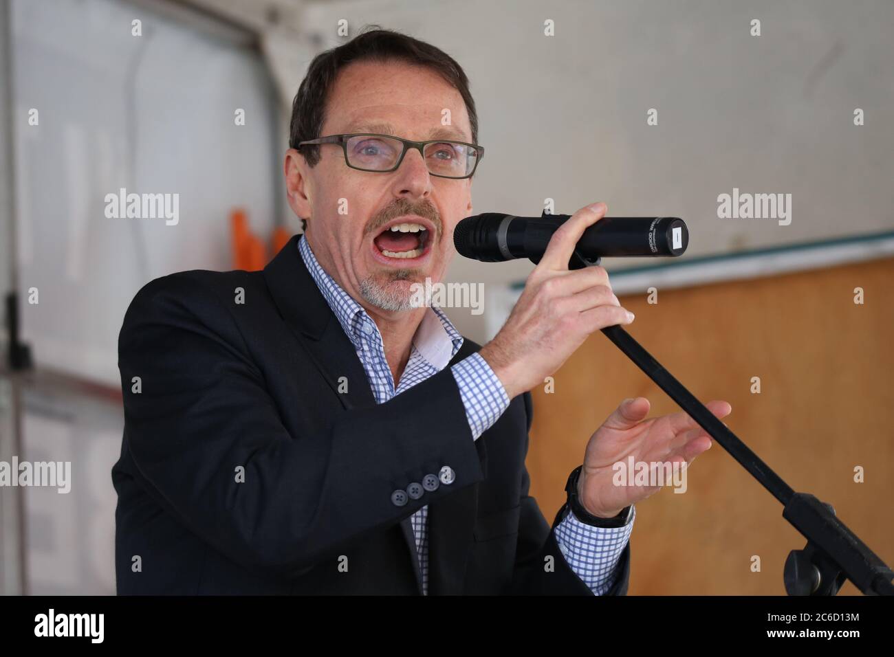 Der Grüne Abgeordnete John Kaye spricht bei einer Kundgebung vor dem NSW-Parlament gegen den liberalen Haushalt und den Verkauf öffentlicher Housi Stockfoto