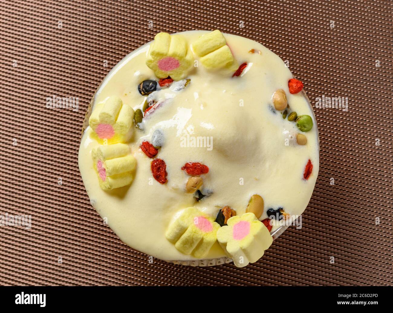 Draufsicht Schüssel schmelzende Eisbecher mit Vanillegeschmack mit Marshmallows und verschiedenen Nüssen Stockfoto
