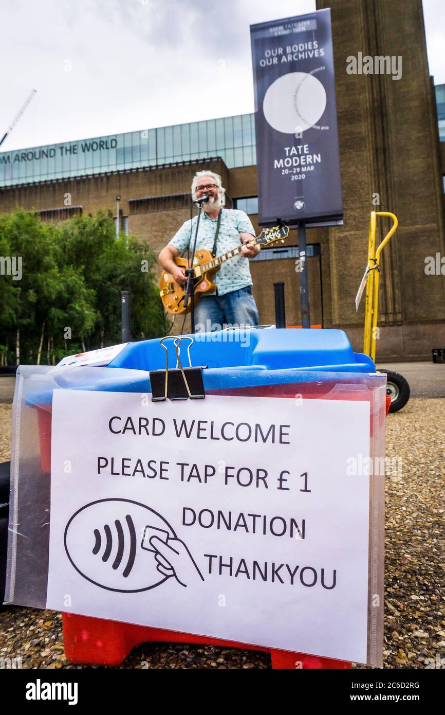 London Busker Gitarre singen und spielen außerhalb der Tate Modern mit bargeldlosem kontaktlosem Zahlungssystem für Spenden, Bankside, London Stockfoto