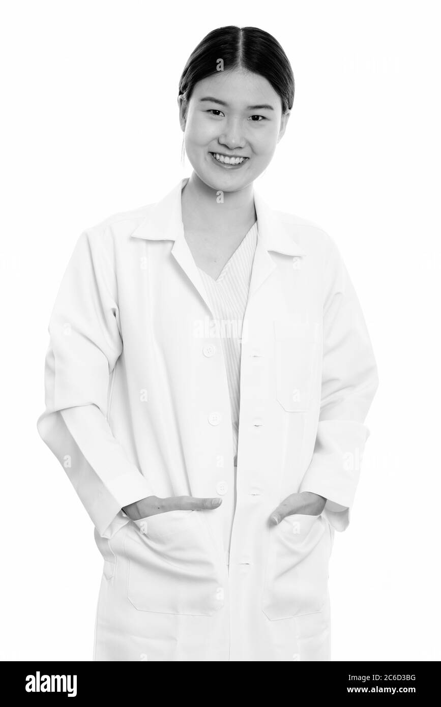 Studio-Aufnahme von jungen glücklich asiatische Frau Arzt lächelnd mit Händen auf Taschen Stockfoto