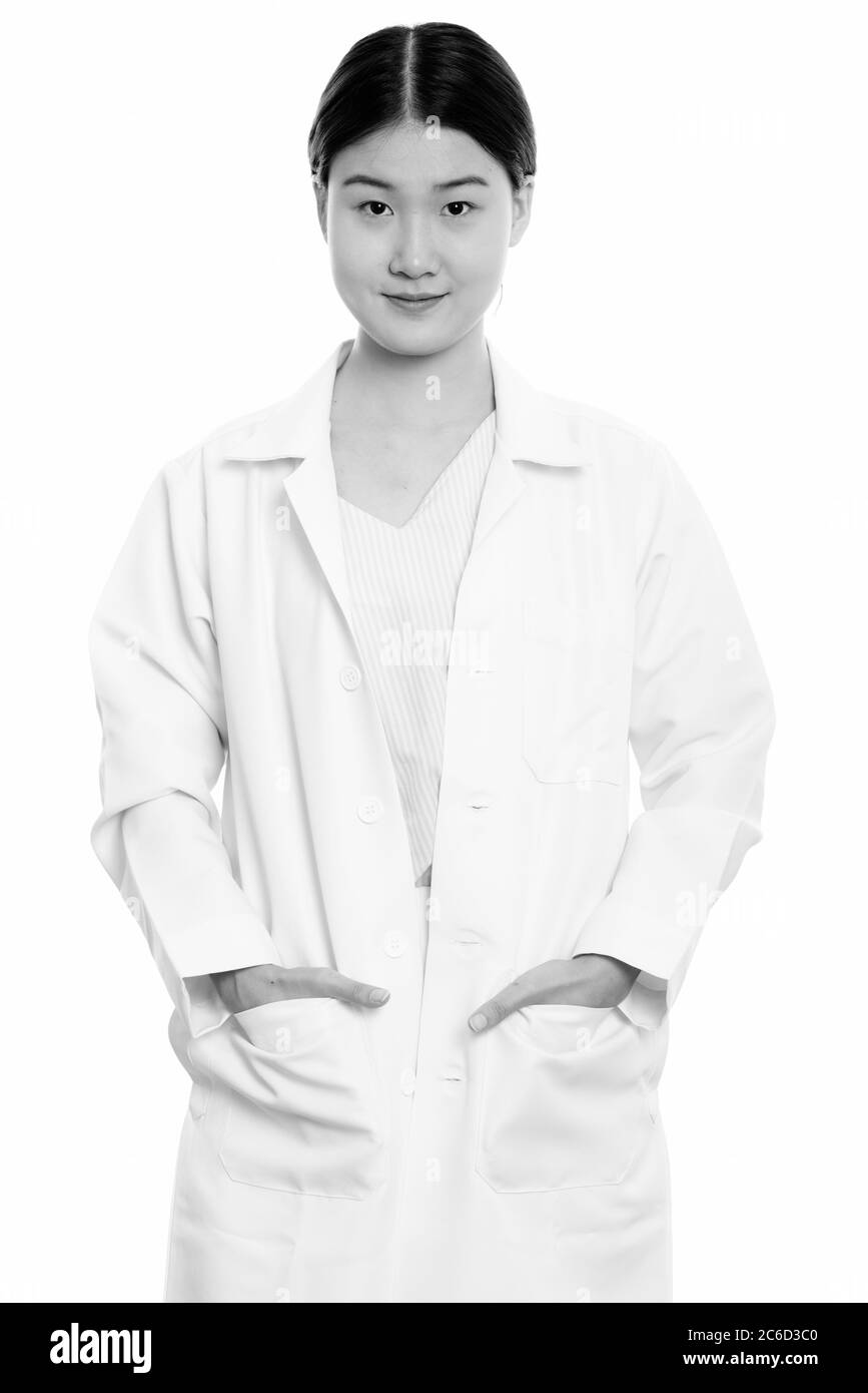 Studio Schuss von jungen schönen asiatischen Frau Arzt mit Händen auf Taschen stehen Stockfoto