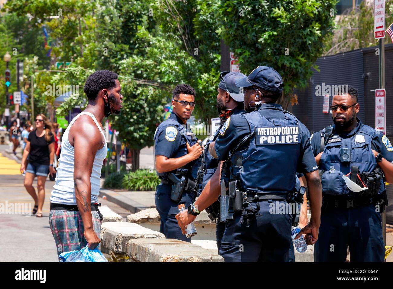 Ein Polizist muss von Kollegen zurückgehalten werden, nachdem er auf eine Frage eines Protesters, Black Lives Matter Plaza Washington, DC, USA, überreagiert hat Stockfoto