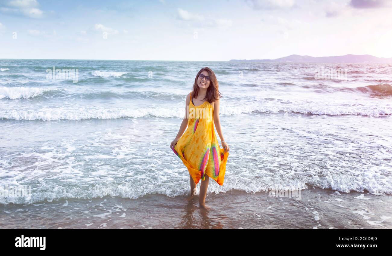 asiatische Frau zu Fuß am Strand im Sommer mit hausgemachten Stoff Mode Stockfoto