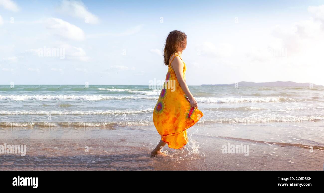 Frau, die im Sommer am Strand mit hausgemachter Stoffmode spazieren geht Stockfoto