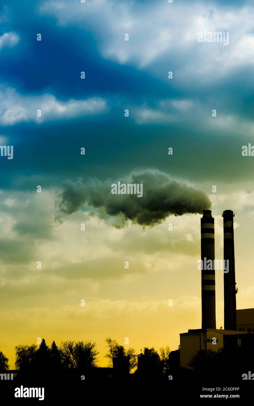 Schornsteine mit Rauch aus einer Industrieanlage, Klimawandel durch menschliche Aktivität und globale Erwärmung Konzept induziert Stockfoto
