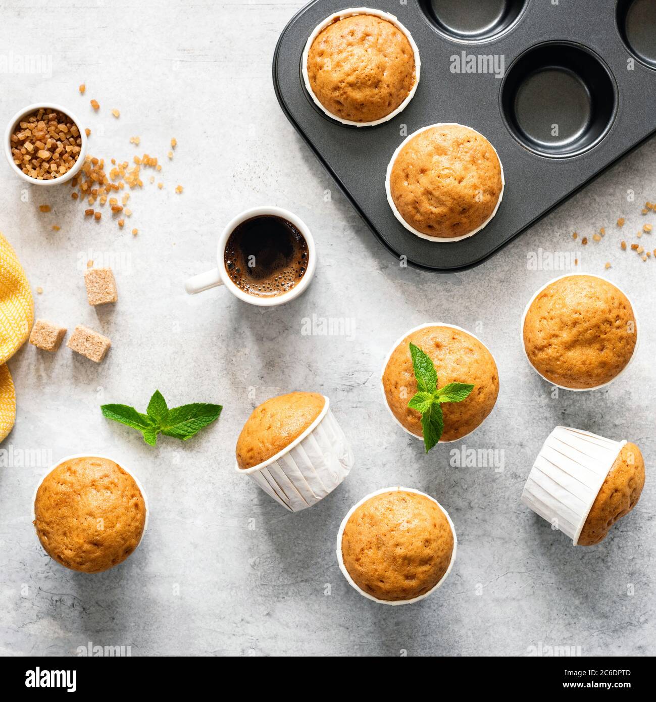 Vanillekaramell Muffins in Pappbechern auf Betonhintergrund, Blick von oben. Backen Muffins Prozess, Lebensmittel Rezept Stockfoto