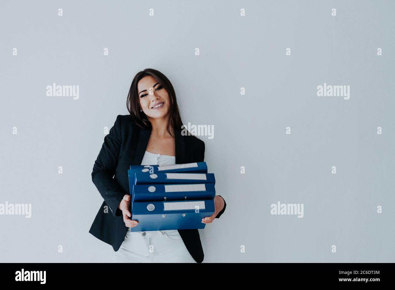 Schöne Brünette Frau in Business-Kleidung mit Ordnern für Papiere im Büro Stockfoto