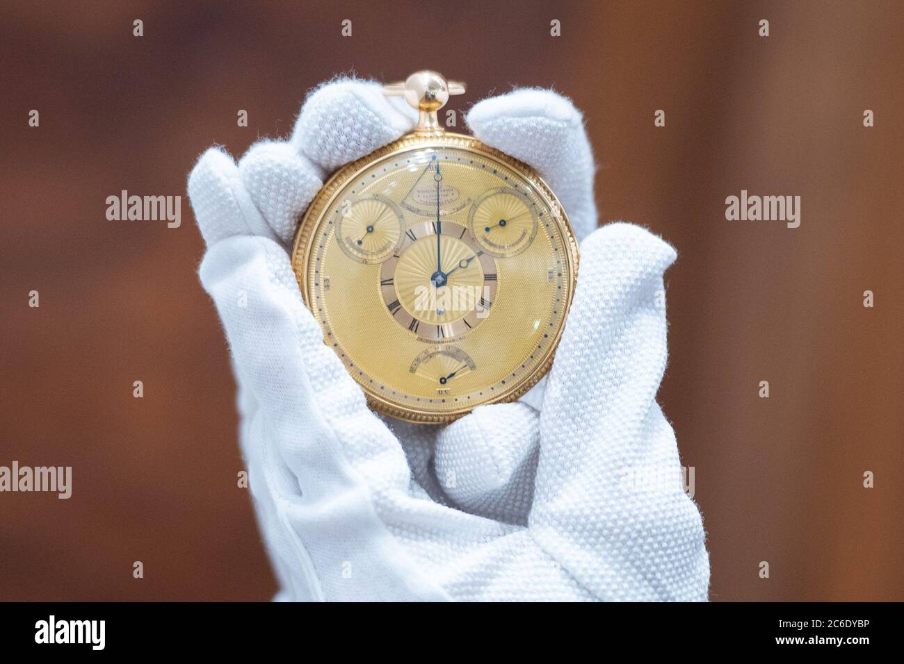 Ein Mitarbeiter von Sotheby's hält die Tourbillon-Uhr von König George III., die vor dem Verkauf durch das Auktionshaus bei Sotheby's im Zentrum von London während der Auktion Collection of a Connoisseur am 4. Juli zu sehen ist. Stockfoto