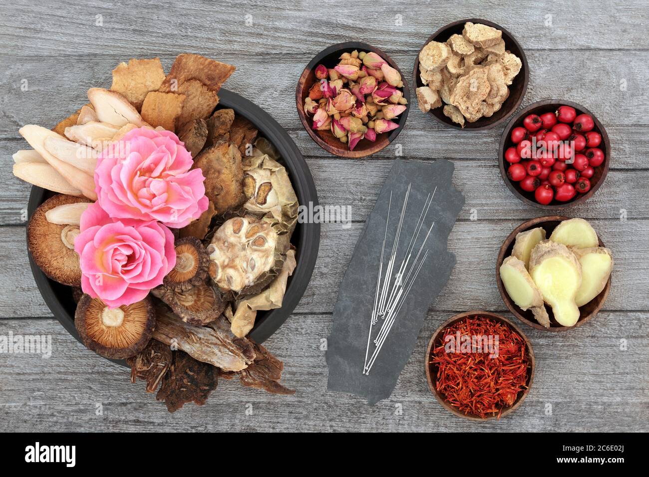 Chinesische Kräuter, Früchte und Blumen & Akupunkturnadeln in der traditionellen Kräutermedizin auf rustikalem Holz Hintergrund verwendet. Natürliche alternative Medizin. Stockfoto