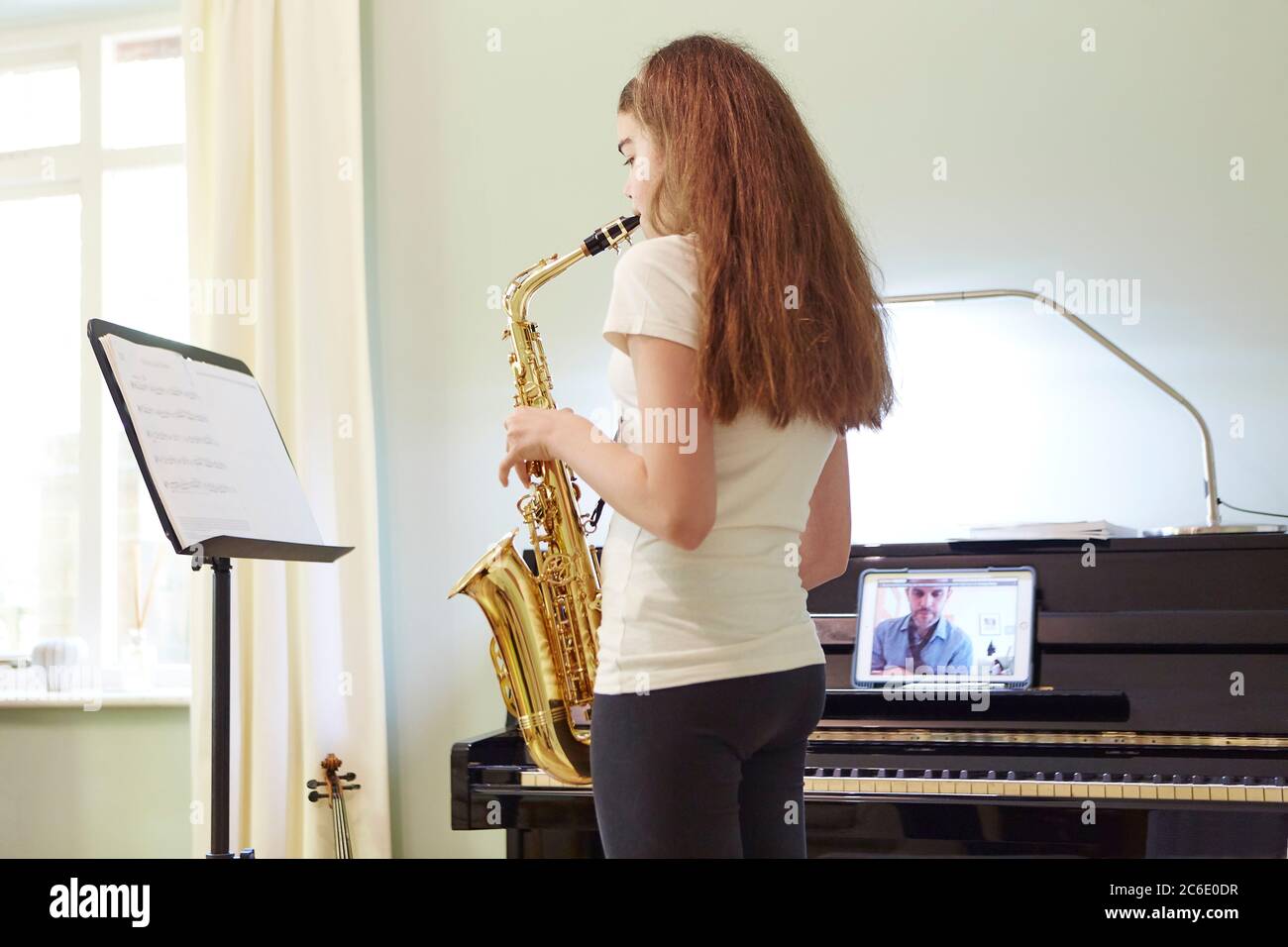 Mädchen nimmt online Saxophon Lektion zu Hause Stockfoto