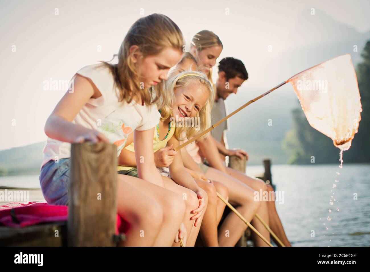 Familie mit Fischernetzen am Dock über dem See Stockfoto