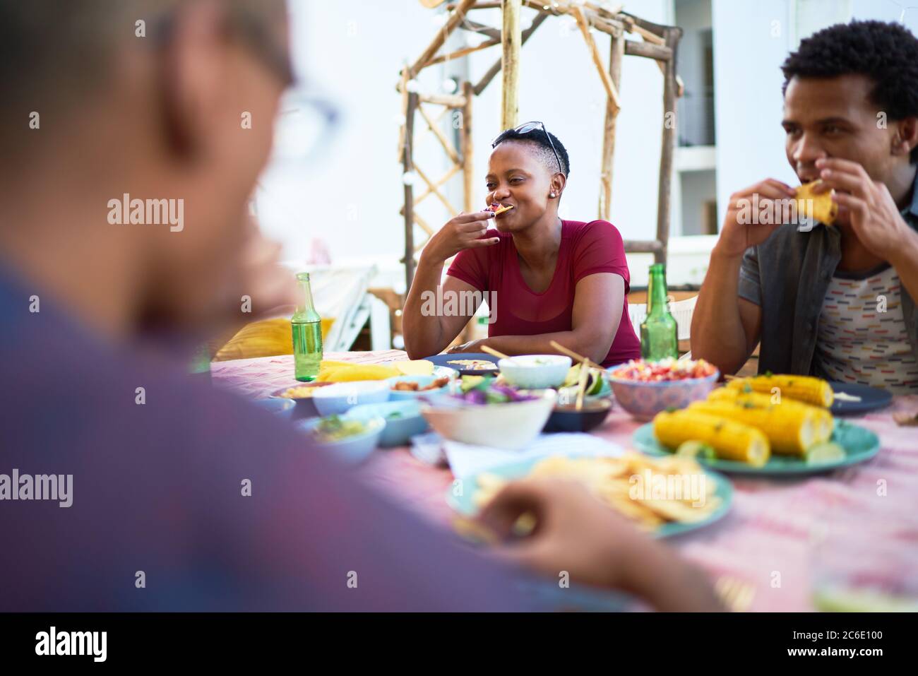 Junge Freunde essen auf der Terrasse zu Abend Stockfoto