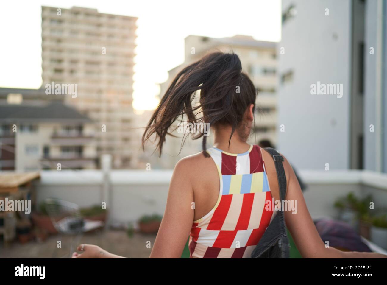 Sorglose junge Frau tanzt auf dem städtischen Dach Stockfoto