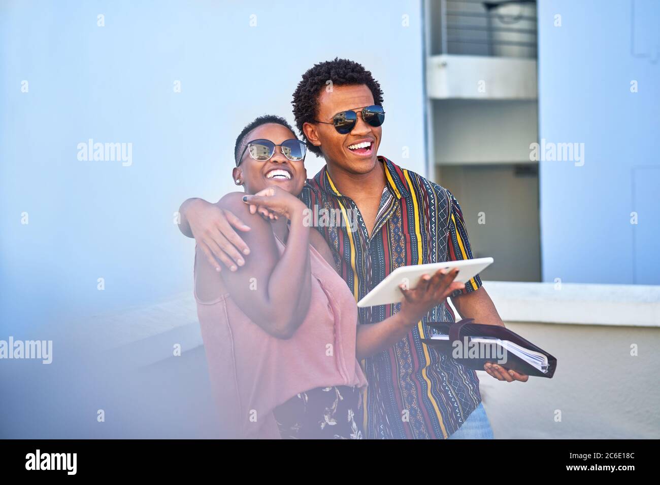 Glückliches junges Paar mit digitalem Tablet auf dem Balkon Stockfoto