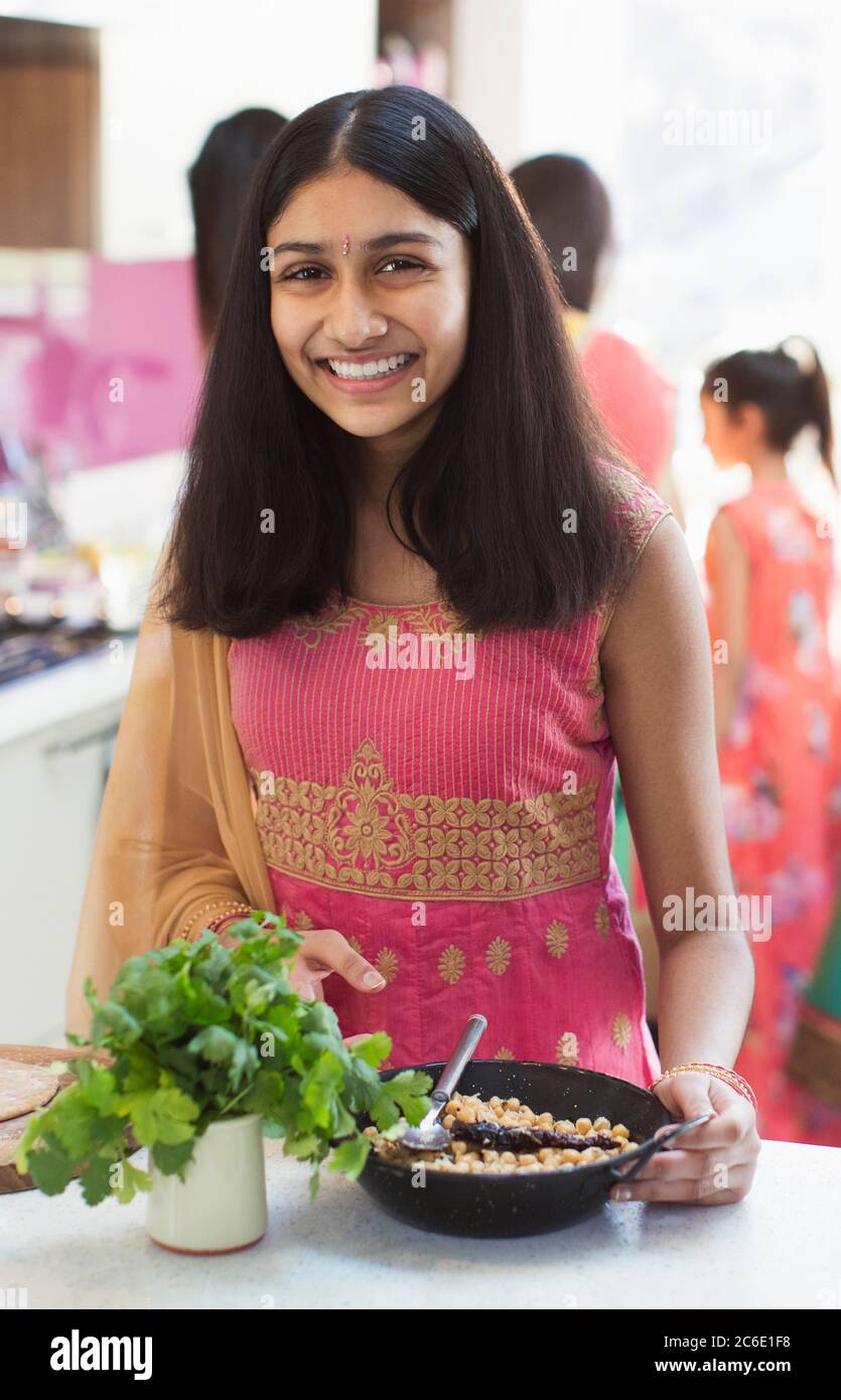 Portrait lächelnd indisches Mädchen in sari essen in der Küche Stockfoto