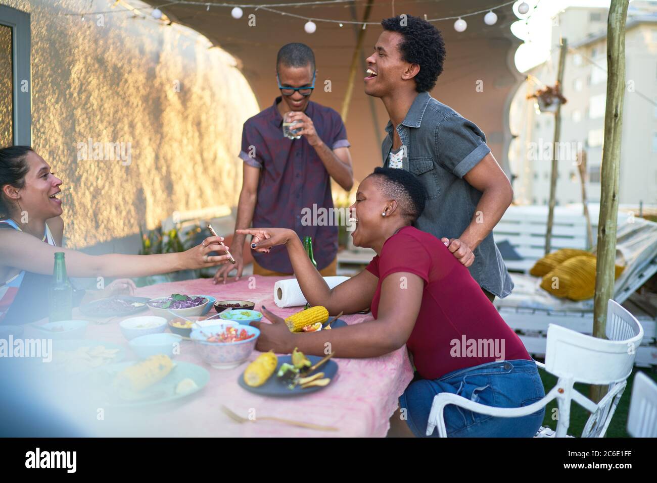 Glückliche junge Freunde mit Smartphone essen Mittagessen auf der Terrasse Tisch Stockfoto