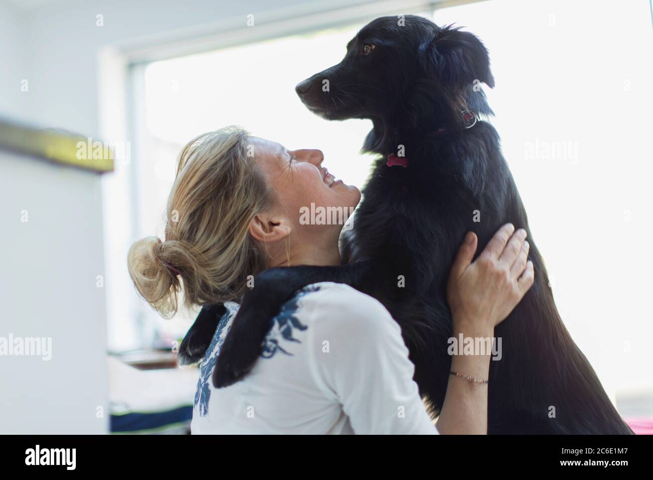Glückliche Frau umarmenden Hund Stockfoto