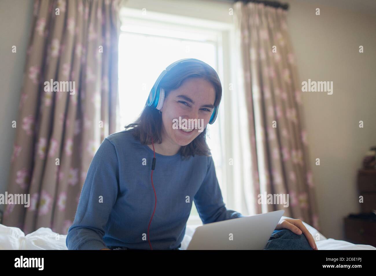 Portrait glücklich Teenager-Mädchen mit Kopfhörer und digitale Tablet auf dem Bett Stockfoto