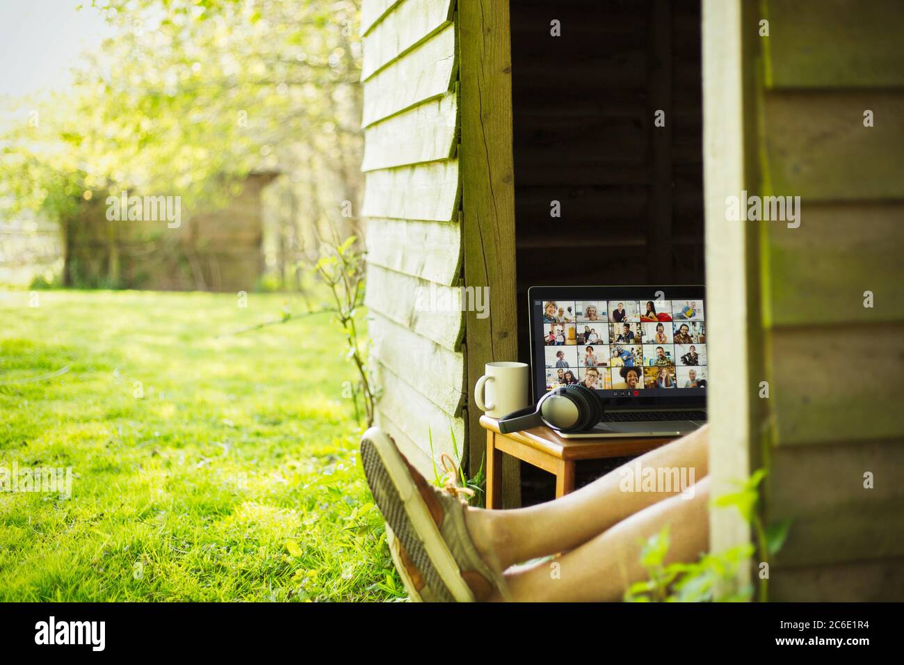 Mann mit Laptop, der Videokonferenz aus dem Gartenhaus genießt Stockfoto