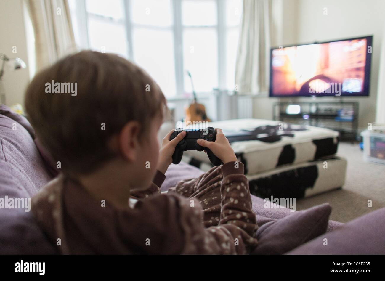 Junge spielt Video Spiel auf Sofa im Wohnzimmer Stockfoto