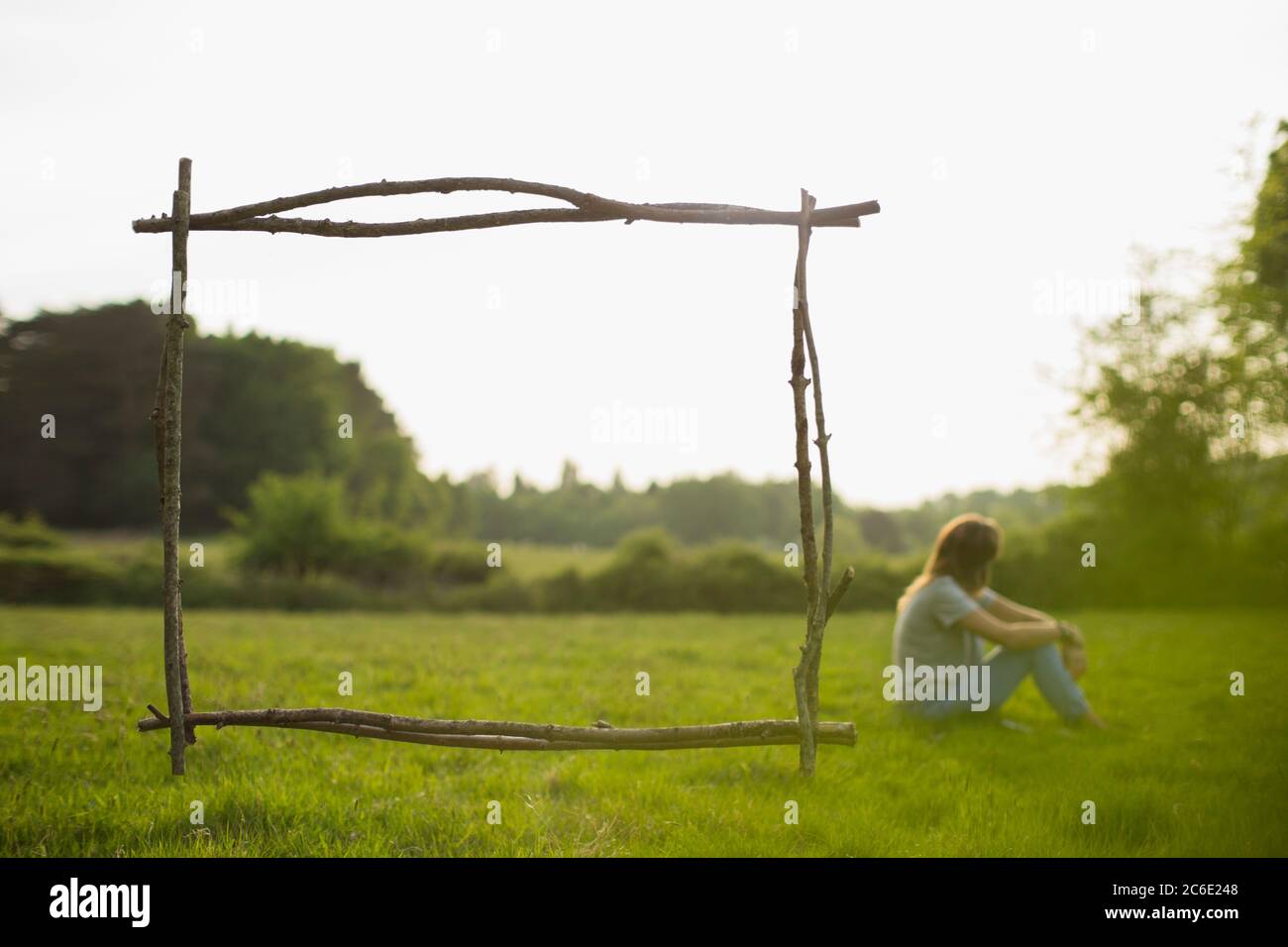 Ast Rahmen über Frau im Sommer Gras Feld entspannen Stockfoto