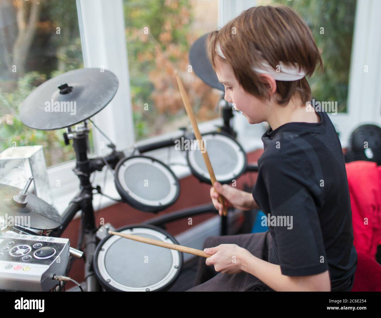 Junge spielt elektronische Trommeln Stockfoto