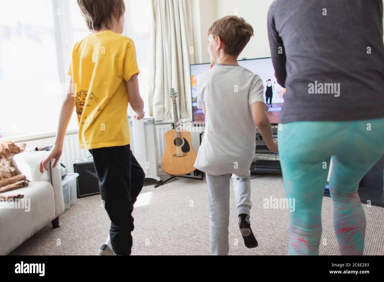 Mutter und Söhne trainieren im Wohnzimmer Stockfoto