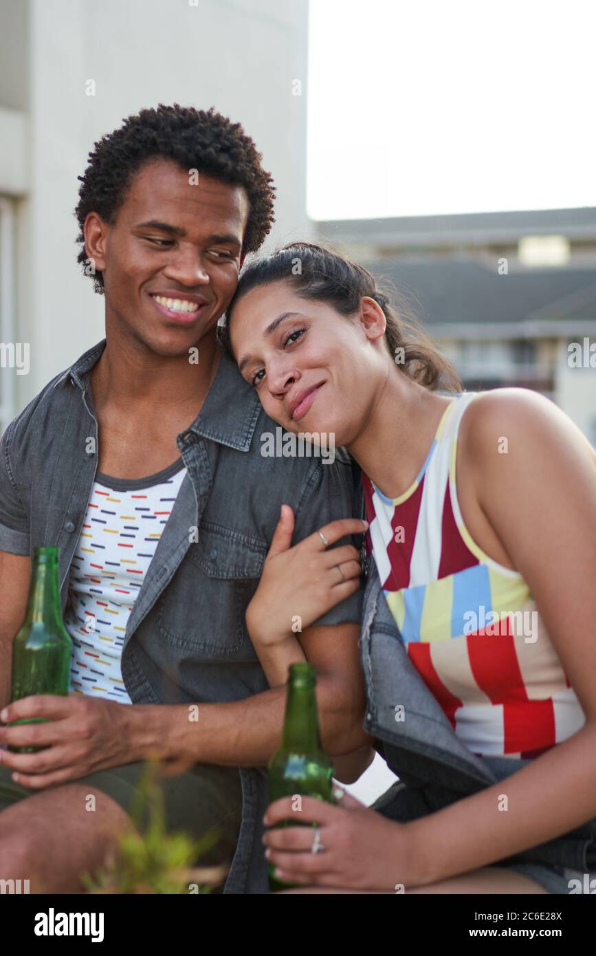 Glückliche junge Freunde trinken Bier auf der Terrasse Stockfoto