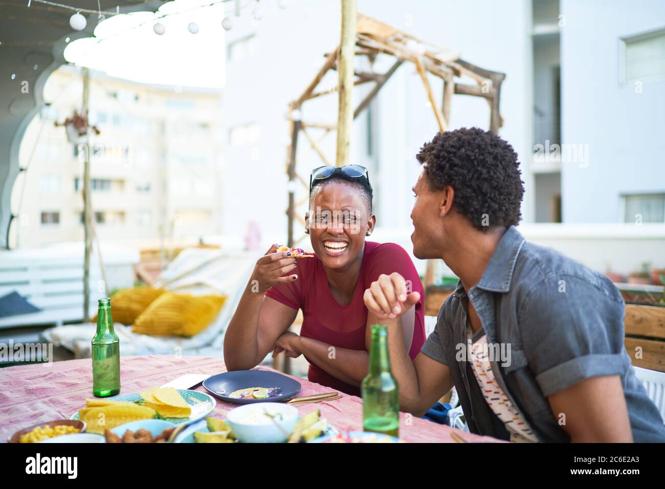Ein glückliches junges Paar, das am Tisch auf der Terrasse zu Mittag gegessen hat Stockfoto