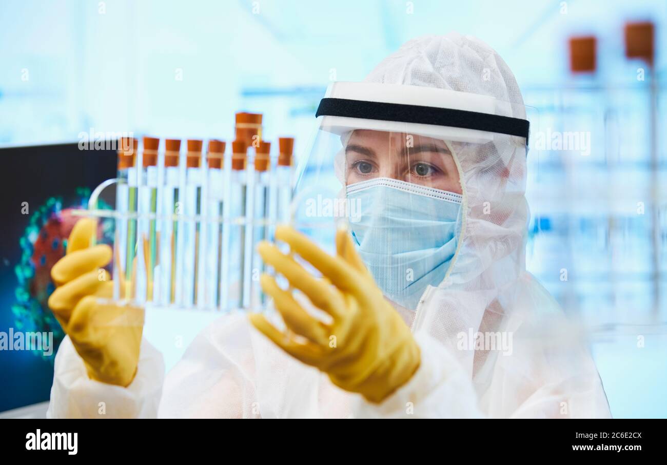 Wissenschaftlerin mit Reagenzgläsern, die den Coronavirus-Impfstoff erforschen Stockfoto