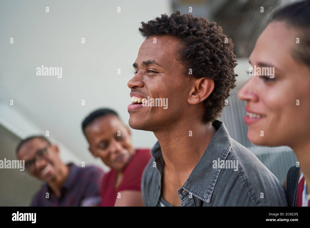 Junger Mann, der mit Freunden rumhängt und lacht Stockfoto
