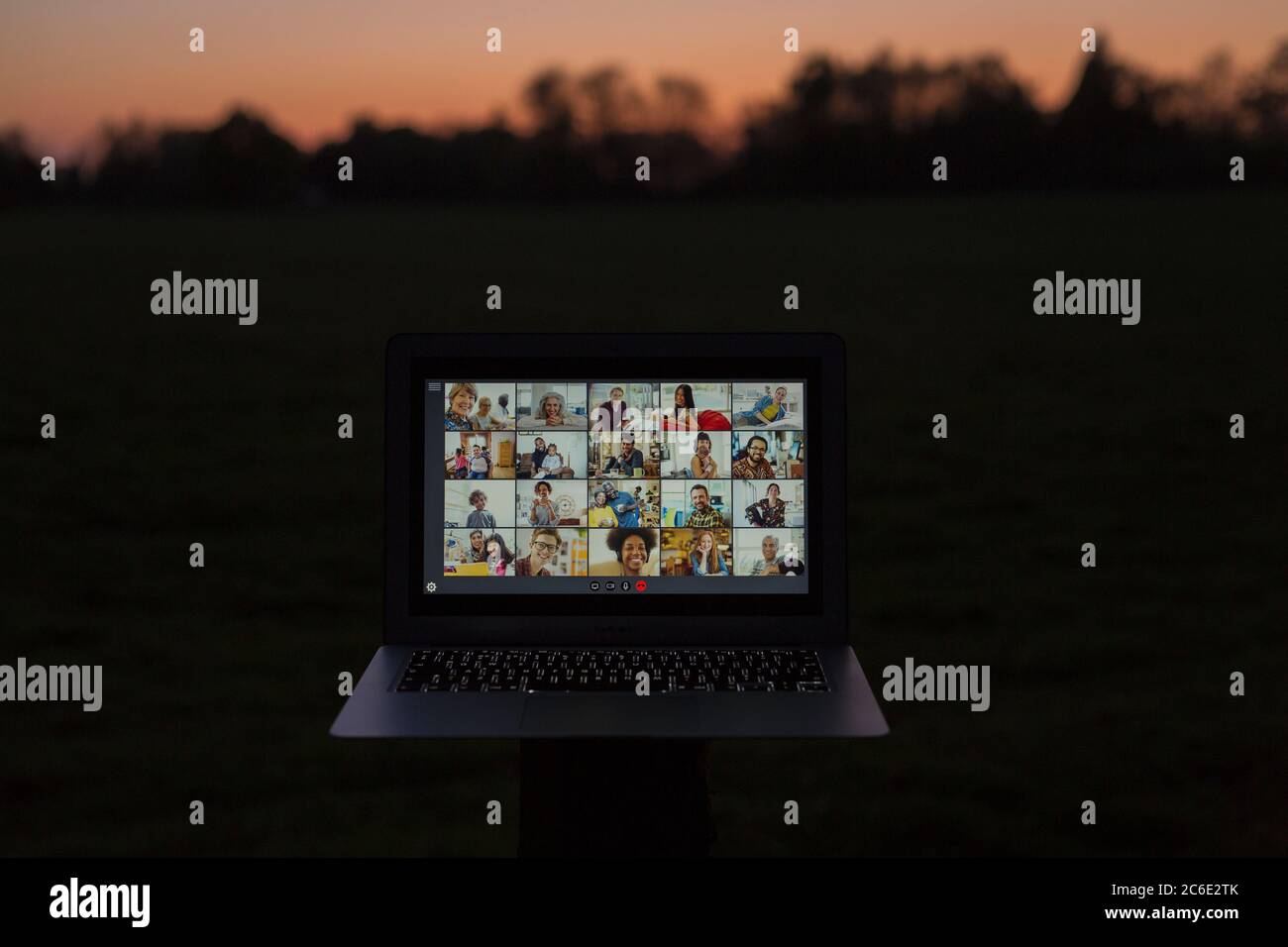 Freunde Video chatten auf Laptop-Bildschirm im Garten in der Dämmerung Stockfoto