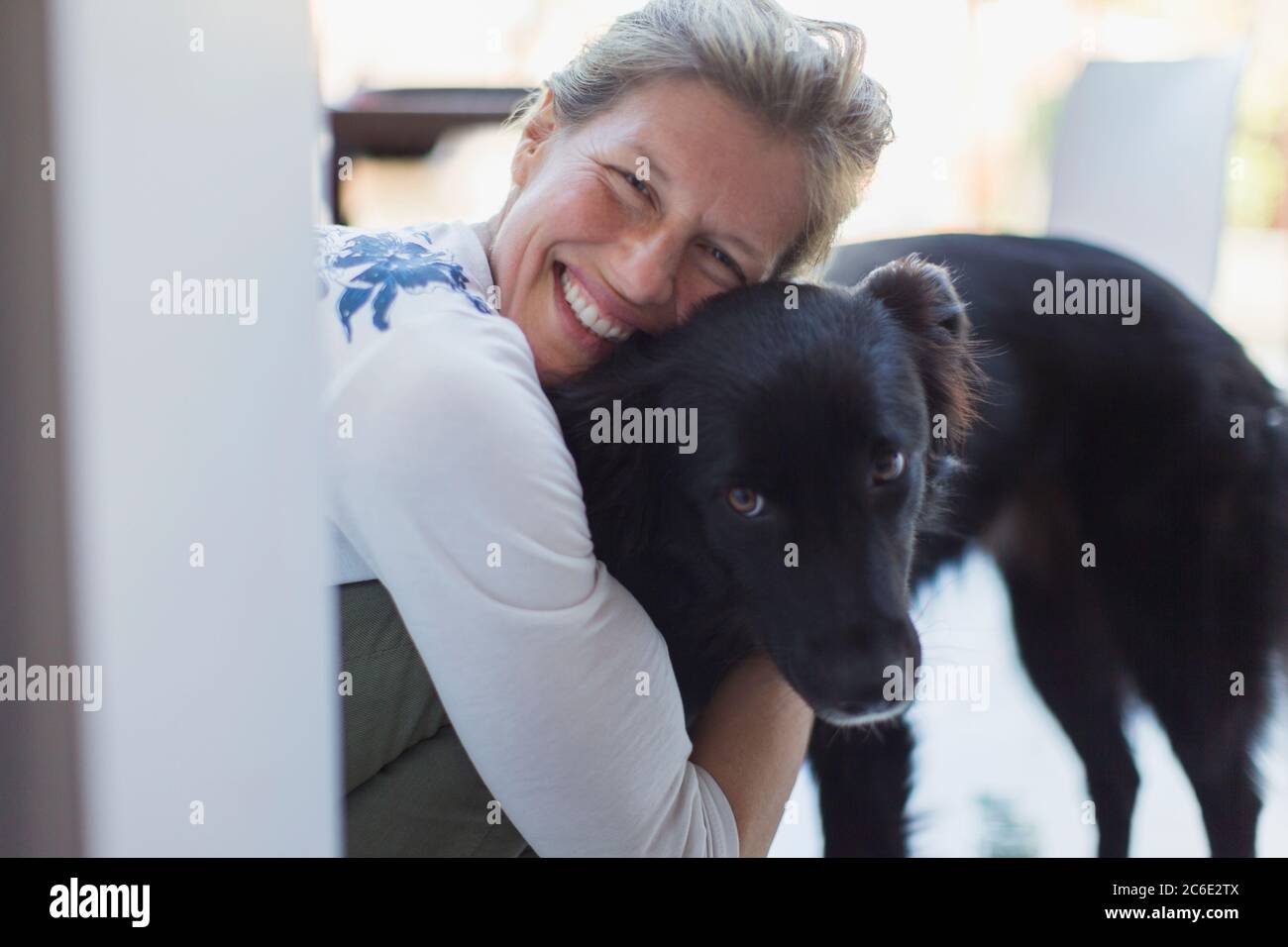 Portrait glücklich Frau umarmenden Hund Stockfoto