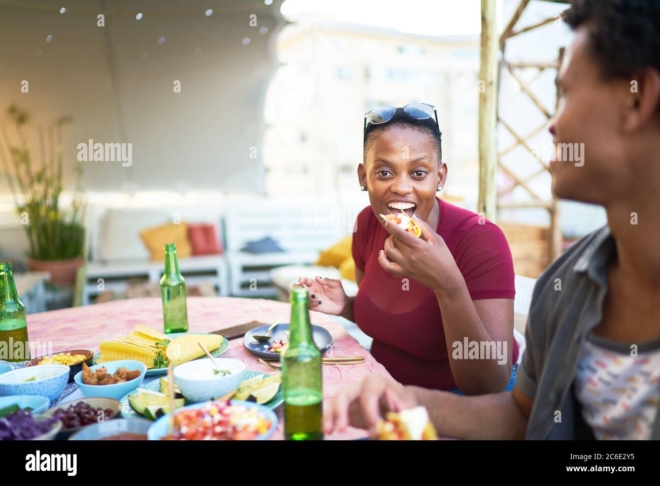 Portrait glücklich junge Frau essen Taco auf der Terrasse Tisch Stockfoto