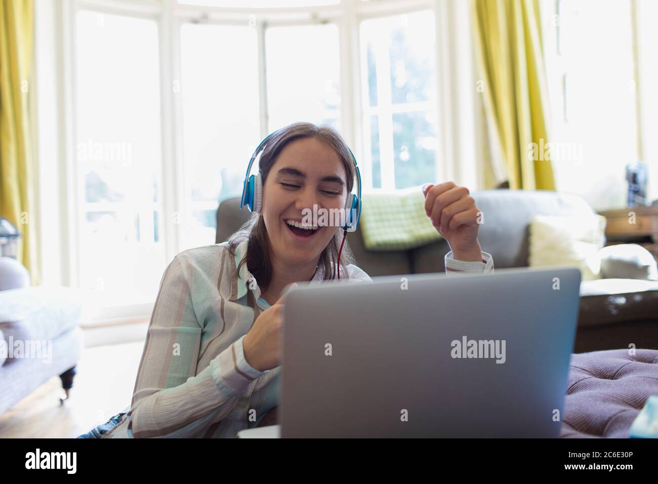 Happy Teenager Mädchen mit Kopfhörer Video chatten am Laptop Stockfoto
