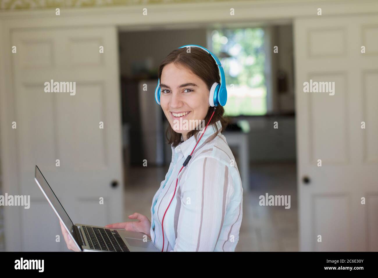 Portrait zuversichtlich Teenager-Mädchen mit Kopfhörer und Laptop Stockfoto
