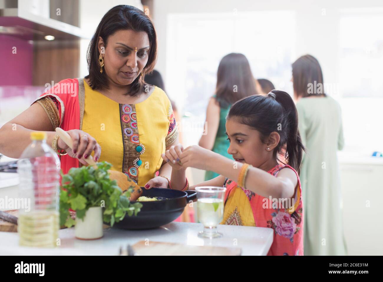 Indische Mutter und Tochter in Saris Kochen Essen in der Küche Stockfoto