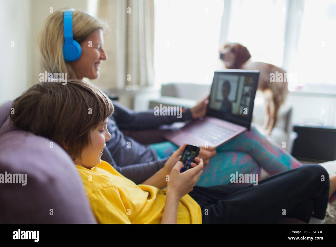 Mutter und Sohn mit Laptop und Smartphone auf dem Sofa Stockfoto