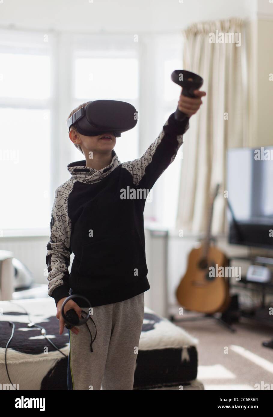 Junge spielt Videospiel mit VRS Brille im Wohnzimmer Stockfoto
